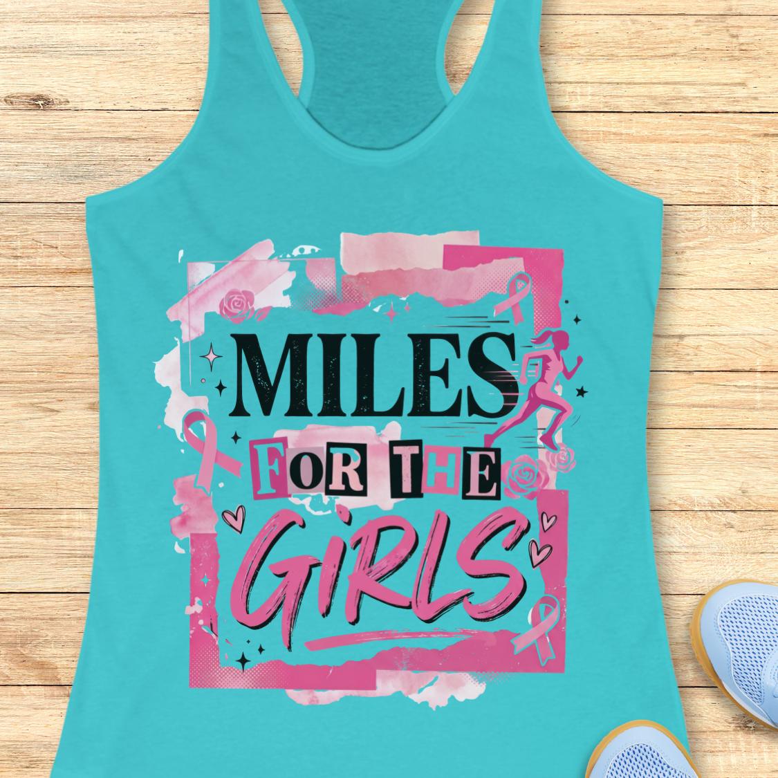 A turquoise racerback tank top laid flat on a light wood background, featuring a pink and black graphic that reads 'MILES FOR THE GIRLS' with ribbon motifs and small runner illustrations. Part of a blue shoe is visible at the bottom right.