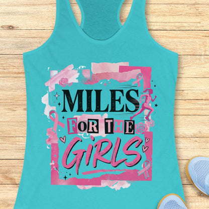 A turquoise racerback tank top laid flat on a light wood background, featuring a pink and black graphic that reads 'MILES FOR THE GIRLS' with ribbon motifs and small runner illustrations. Part of a blue shoe is visible at the bottom right.