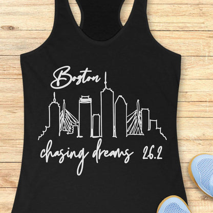 Black tank top with white 'Boston chasing dreams 26.2' design on a wooden surface