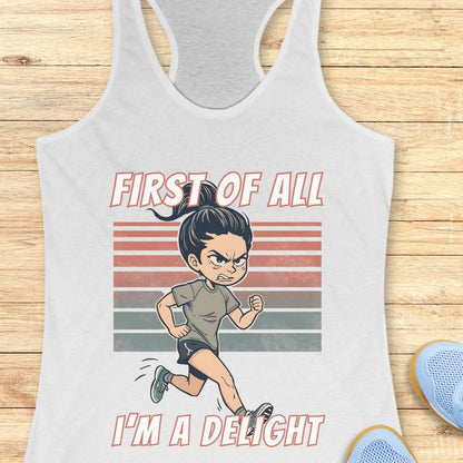 white Tank top with a graphic of a girl running and text 'First of all, I'm a delight' on a wooden surface.