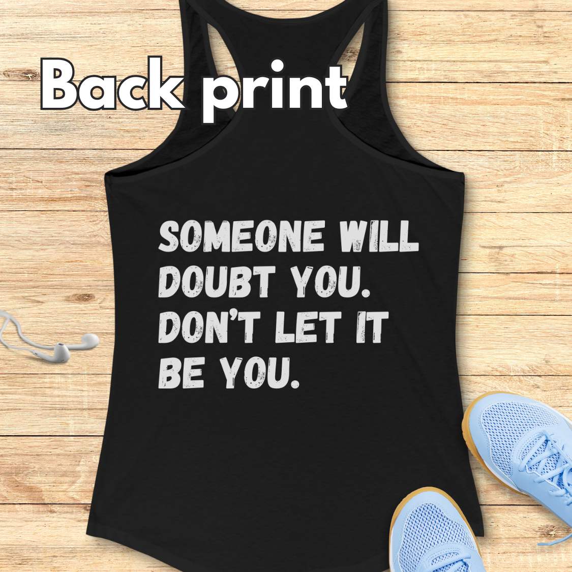a black tank op with a text at the back of the tank top "Someone will doubt you. Don't let it be you." on a wooden background