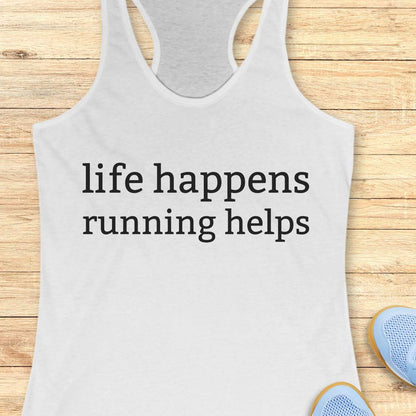white tank top with 'life happens running helps' text on a wooden surface.