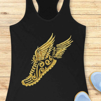 Digital mock-up of a black racerback tank top featuring a golden winged running shoe with intricate filigree details set against a light wooden plank background with light blue sneakers partially visible on the right