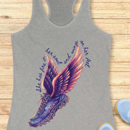 Gray tank top with Digital graphic print  featuring a winged running shoe design with elaborate purple and blue swirling patterns, vibrant purple pink orange and yellow wings, and text reading she has fire in her soul and wings on her feet surrounding it