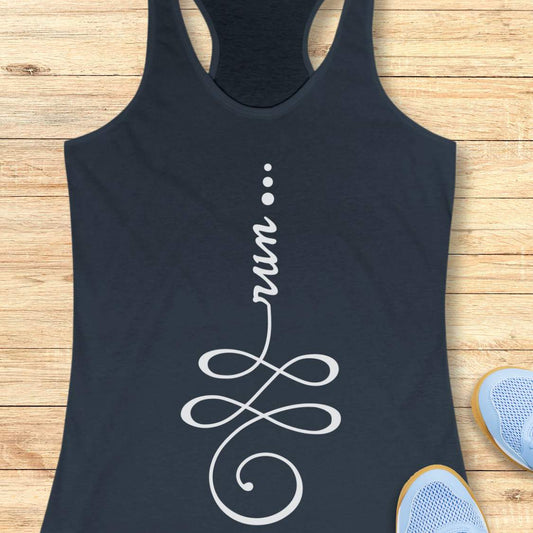 an indigo racerback tank top with a white graphic design featuring the word 'run' integrated into an infinity symbol, laid flat on a light wood plank background with blue sneakers partially visible at the bottom right.