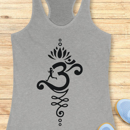 A heather gray racerback tank top with a black Om symbol graphic featuring a running figure and lotus design, displayed flat on a light wood background with partial blue sneakers visible at the corners.