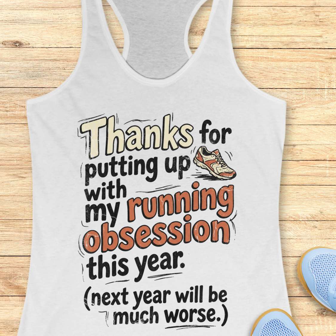 White tank top with humorous text design on a wooden surface