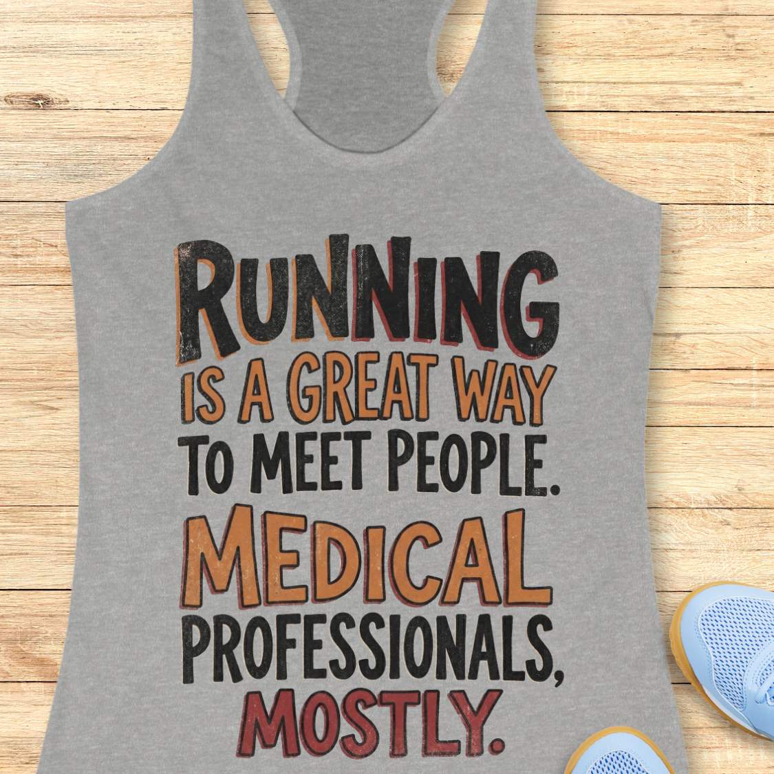 Gray tank top with humorous text on a wooden surface