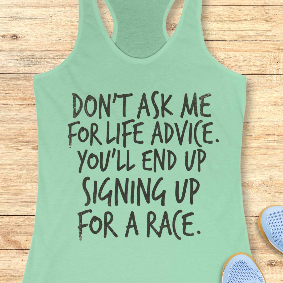 A mint green racerback tank top with black text reading 'DON'T ASK ME FOR LIFE ADVICE. YOU'LL END UP SIGNING UP FOR A RACE.