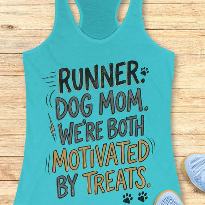 A turquoise racerback tank top laid flat on a light wood surface, printed with the phrase 'RUNNER DOG MOM WE'RE BOTH MOTIVATED BY TREATS.' in dark gray and tan lettering with small paw print and lightning bolt accents.
