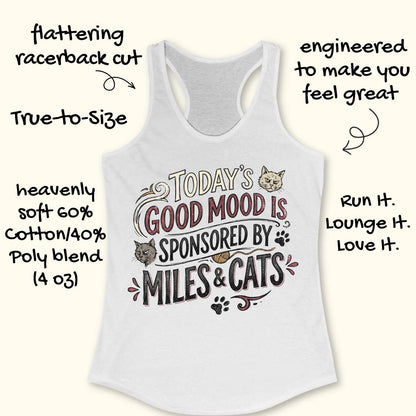 A white racerback tank top with a graphic that reads 'TODAY'S GOOD MOOD IS SPONSORED BY MILES & CATS' with cat illustrations and paw prints. Hand-drawn text around the garment highlights its features, such as flattering racerback cut, true-to-size, and soft cotton/poly blend fabric.