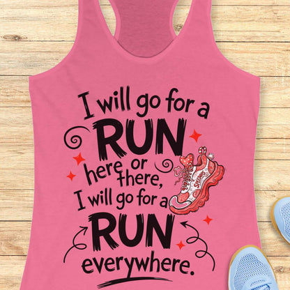 A pink racerback tank top laid flat on a light wood background, featuring a motivational quote in black and white text that reads 'I will go for a RUN here or there, I will go for a RUN everywhere.' with a red and white running shoe illustration and small red star accents.