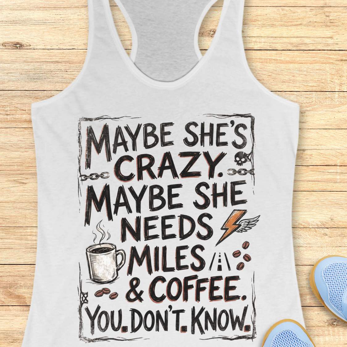 A white racerback tank top with a humorous graphic print reading 'MAYBE SHE'S CRAZY. MAYBE SHE NEEDS MILES & COFFEE.