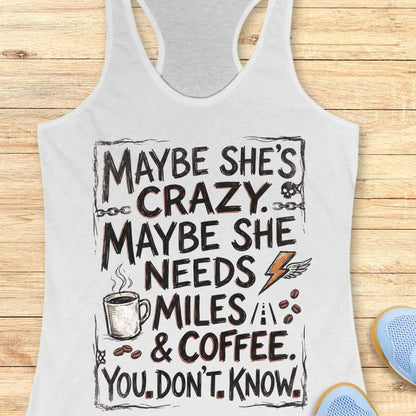 A white racerback tank top with a humorous graphic print reading 'MAYBE SHE'S CRAZY. MAYBE SHE NEEDS MILES & COFFEE.