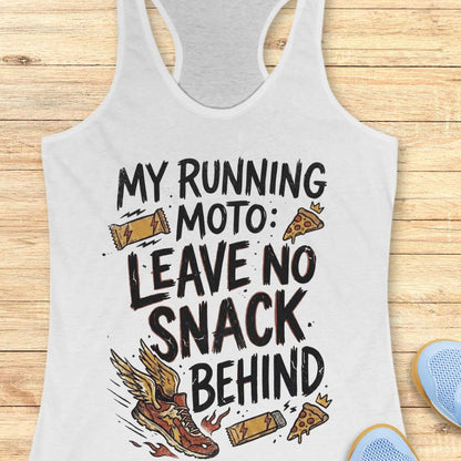 A white racerback tank top laid flat on a light wood background, featuring a humorous graphic that reads 'MY RUNNING MOTO: LEAVE NO SNACK BEHIND' with illustrations of a running shoe, pizza slices, and candy bars.