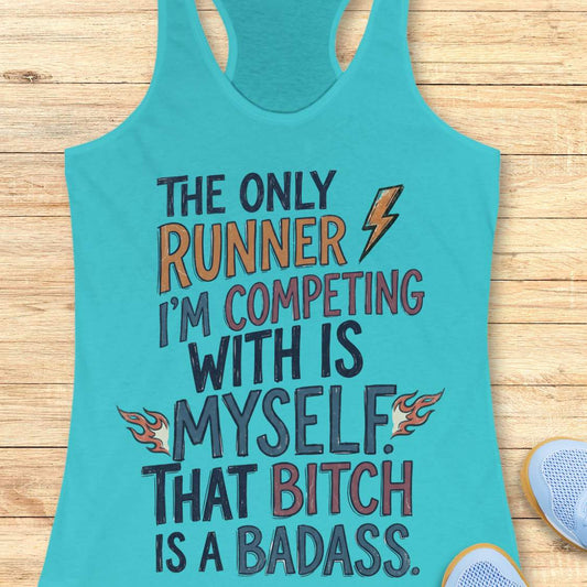 A turquoise racerback tank top laid flat on a light wood surface, featuring a motivational graphic with the text 'THE ONLY RUNNER I'M COMPETING WITH IS MYSELF. THAT BITCH IS A BADASS.