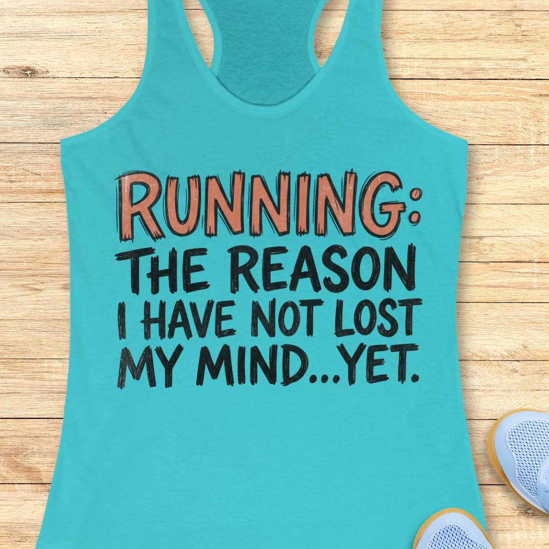 A turquoise racerback tank top laid flat on a light wood surface, printed with the phrase 'RUNNING: THE REASON I HAVE NOT LOST MY MIND.