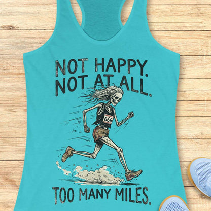 A turquoise racerback tank top laid flat on a light wood surface, featuring a distressed black graphic of a running skeleton with the text 'NOT HAPPY. NOT AT ALL.