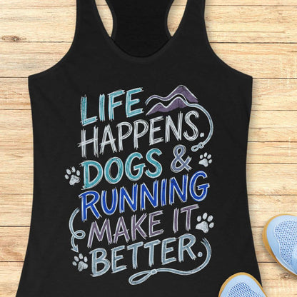 A black racerback tank top laid flat on a light wood surface, featuring a colorful graphic that reads 'LIFE HAPPENS. DOGS & RUNNING MAKE IT BETTER.