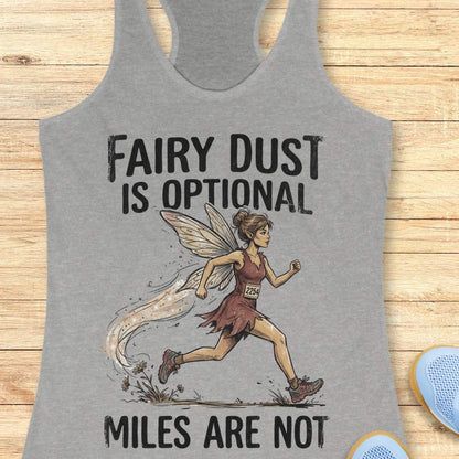 A heather gray racerback tank top laid flat on a light wood background, featuring a printed graphic of a fairy-themed runner with the text 'FAIRY DUST IS OPTIONAL' and 'MILES ARE NOT'.