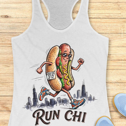 white women's racerback tank top featuring a playful illustration of a running hot dog wearing sunglasses and colorful running shoes. The hot dog has a race bib that reads “RUN THE WINDY CITY 312” and is jogging in front of a hand-drawn Chicago skyline. The design includes classic Chicago-style hot dog toppings such as tomatoes, pickles, mustard, and relish. Large text below the illustration reads: “RUN CHI.” The artwork combines running humor with Chicago pride in a fun, cartoon-style design.