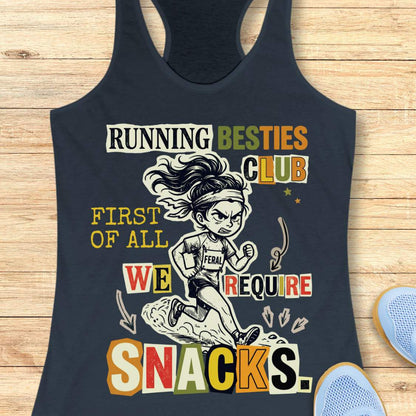 A indigo racerback tank top with a colorful graphic print on a light wood background. The graphic features a cartoon illustration of a female runner and the text 'RUNNING BESTIES CLUB FIRST OF ALL WE REQUIRE SNACKS.