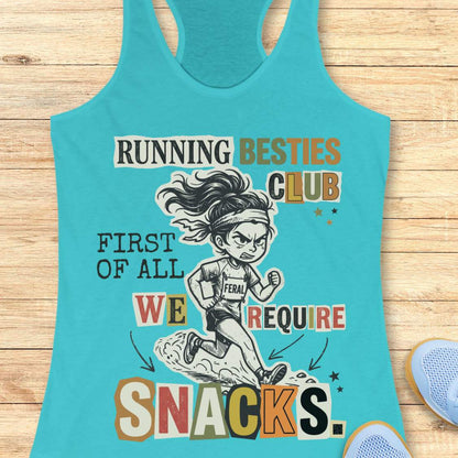 A turquoise racerback tank top laid flat on a light wood surface, featuring a colorful graphic of a running girl and the text 'RUNNING BESTIES CLUB FIRST OF ALL WE REQUIRE SNACKS.' A partial blue shoe is visible at the lower right corner.