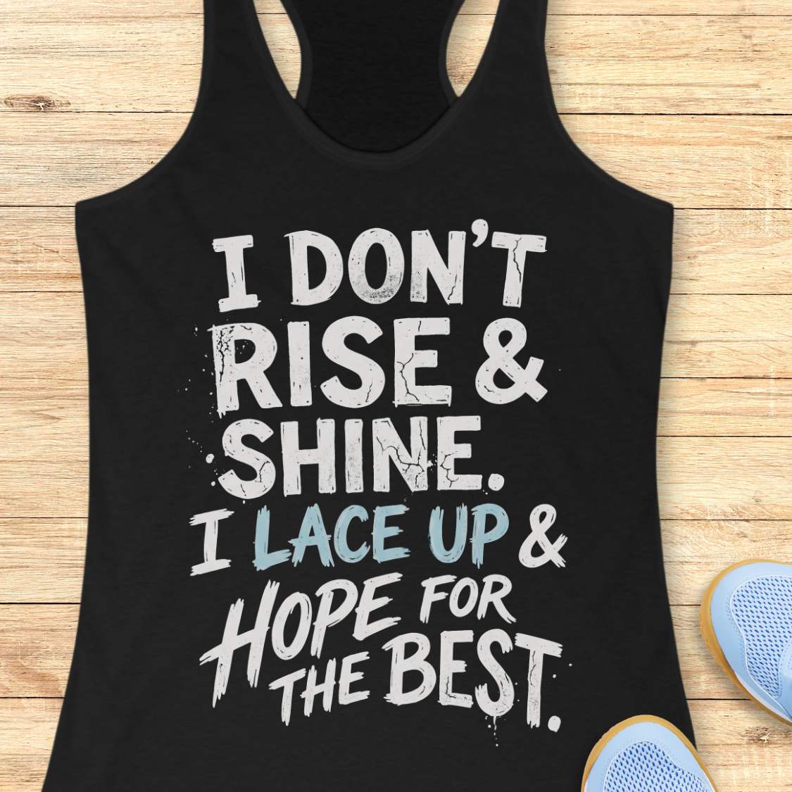 black racerback tank top featuring a bold, distressed typography design that reads: “I DON’T RISE & SHINE. I LACE UP & HOPE FOR THE BEST.” The text is displayed in a mix of black and brown brush-style lettering, creating a playful and relatable message for runners who prefer determination over morning enthusiasm. The humorous running-themed design is ideal for athletes, joggers, and fitness enthusiasts.