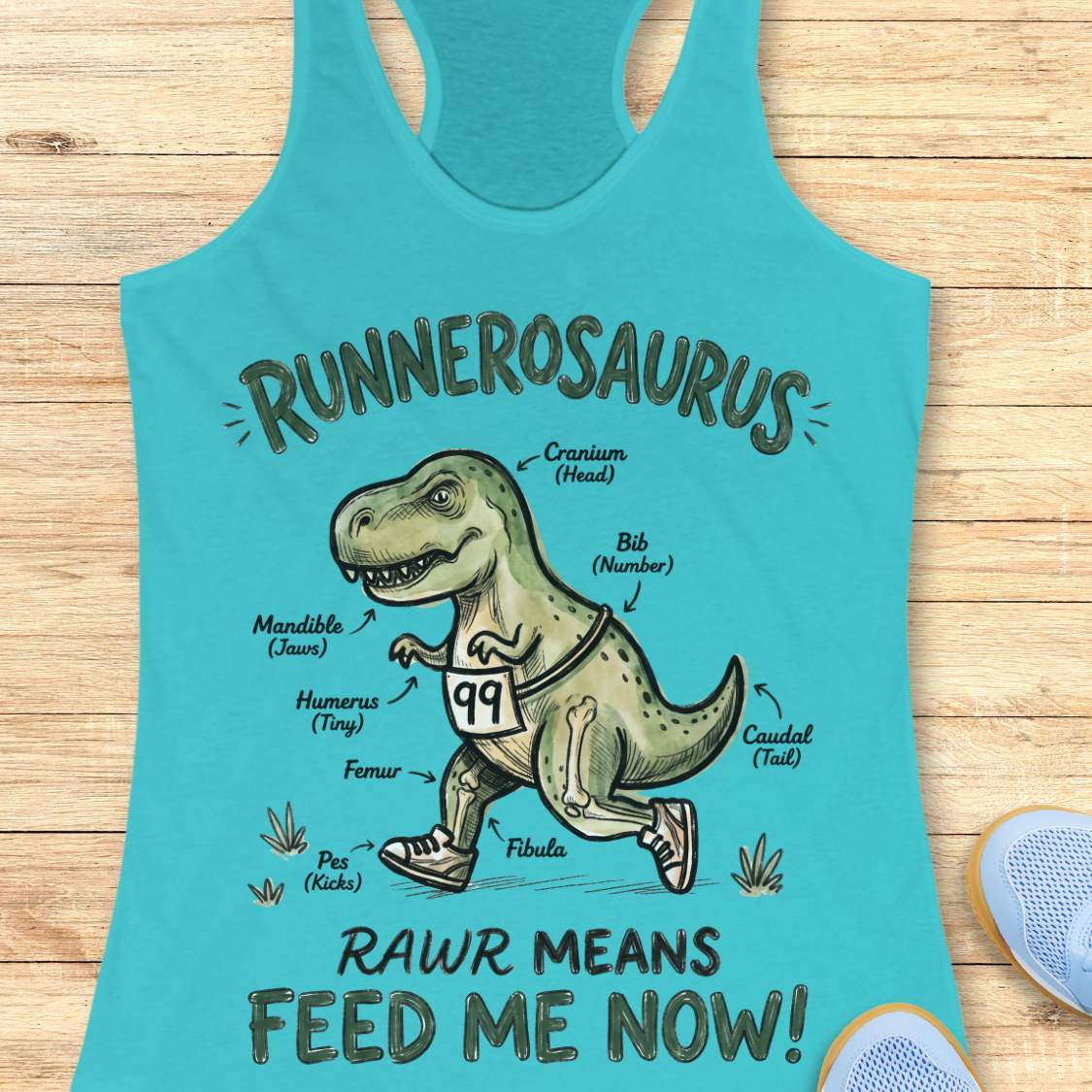 blue racerback tank top featuring a playful dinosaur running graphic and the phrase, “RUNNEROSAURUS RAWR MEANS FEED ME NOW!” The design shows a cartoon T-Rex wearing running shoes and race bib number 99, illustrated like an anatomy diagram with humorous labels such as “Cranium (Head),” “Mandible (Jaws),” “Humerus (Tiny),” “Pes (Kicks),” and “Caudal (Tail).” The lighthearted running-themed artwork combines dinosaur humor with runner culture, making it a fun choice for runners, joggers, and dinosaur ent