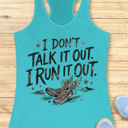 A turquoise racerback tank top laid flat on a light wood background, featuring a distressed black graphic that reads 'I DON'T TALK IT OUT. I RUN IT OUT.