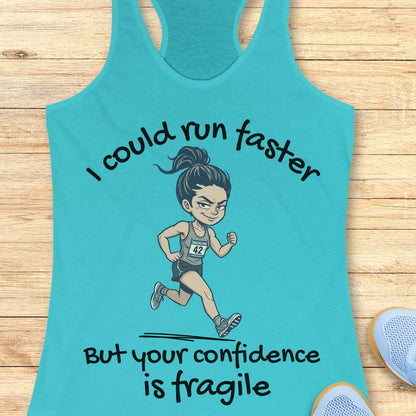 A turquoise racerback tank top laid flat on a light wood surface, featuring a cartoon runner graphic and the text 'I could run faster But your confidence is fragile.' Partial blue shoes are visible at the bottom right as styling props.