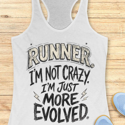 A white racerback tank top laid flat on a light wood background, featuring the text 'RUNNER. I'M NOT CRAZY.