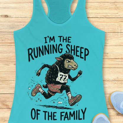 A turquoise racerback tank top laid flat on a light wood surface, featuring a cartoon running sheep wearing bib number 77 and the text “I'M THE RUNNING SHEEP OF THE FAMILY.” Partial blue shoes are visible at the bottom right as styling props.