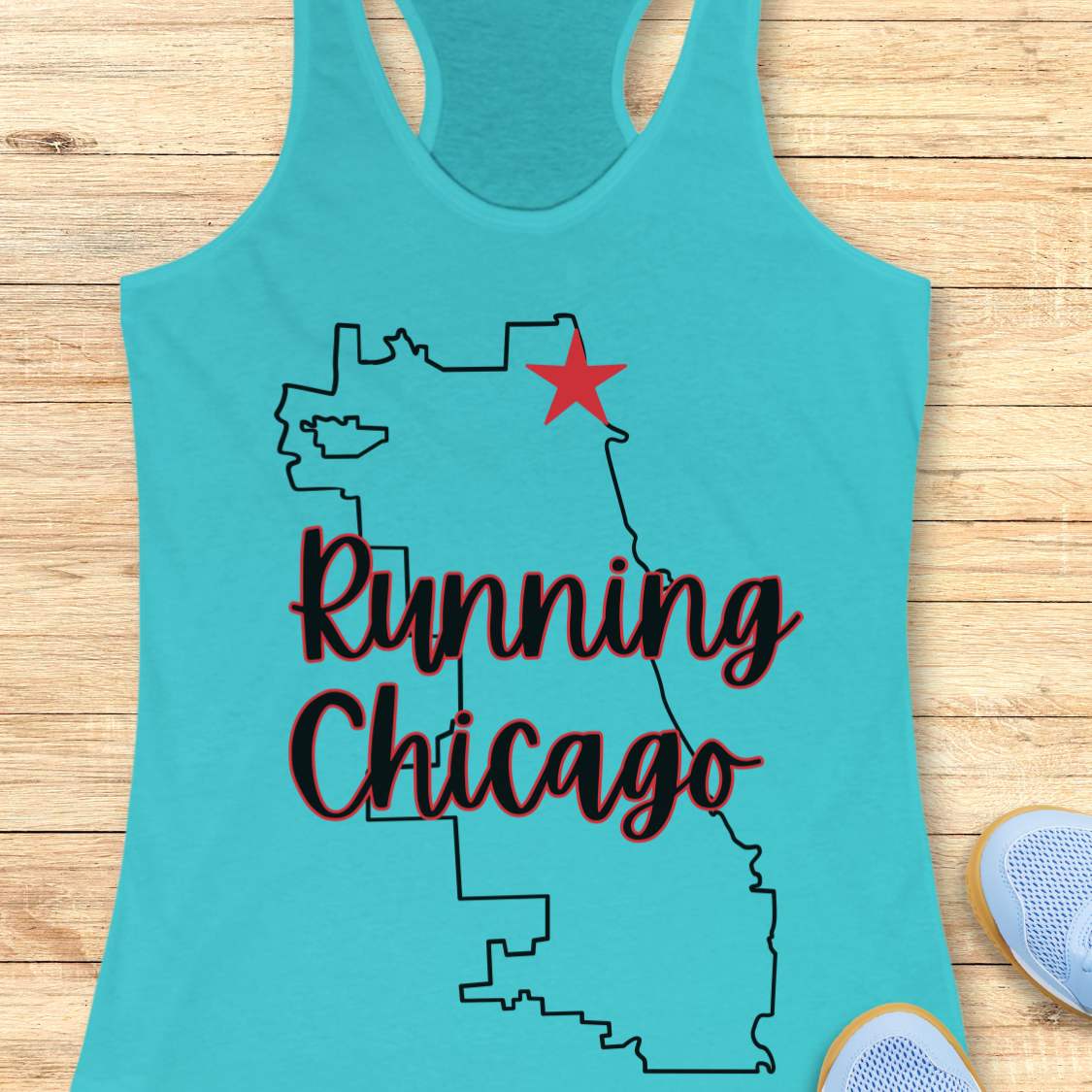 blue racerback running tank top featuring a minimalist white outline of the city of Chicago. A large red six-pointed star, inspired by the Chicago flag, marks a location near the upper right section of the city outline. The words “Running Chicago” appear in large script lettering layered over the map design. The tank top is displayed on a light wood background with partial blue running shoes visible in the bottom corners. The design has a clean, modern look celebrating running in Chicago.