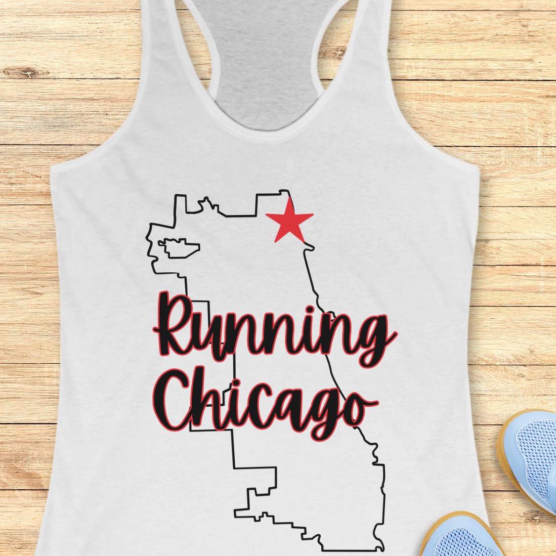 white racerback running tank top featuring a minimalist white outline of the city of Chicago. A large red six-pointed star, inspired by the Chicago flag, marks a location near the upper right section of the city outline. The words “Running Chicago” appear in large script lettering layered over the map design. The tank top is displayed on a light wood background with partial blue running shoes visible in the bottom corners. The design has a clean, modern look celebrating running in Chicago.