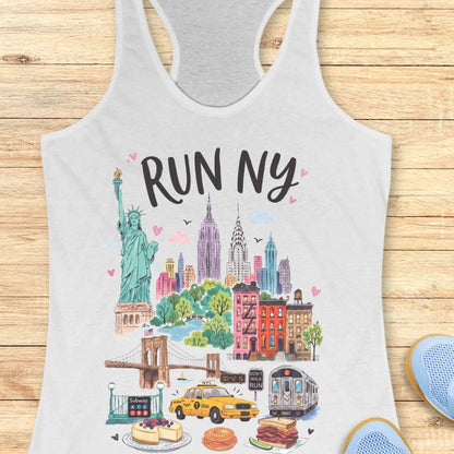 White racerback running tank top featuring a colorful illustrated “RUN NY” design. The artwork showcases iconic New York City landmarks and symbols, including the Statue of Liberty, the Empire State Building, the Chrysler Building, the Brooklyn Bridge, brownstone row houses, a subway train, and a subway entrance. Additional New York elements include a yellow taxi cab, a race clock, a pedestrian crossing sign that reads “DON'T WALK RUN,” Central Park-inspired greenery, cheesecake, a bagel sandwich, and a pas