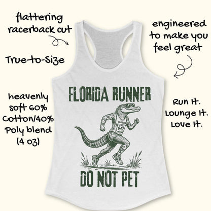 A white racerback tank top laid flat on a light wood background, featuring a dark green graphic of an alligator running with the text 'FLORIDA RUNNER' above and 'DO NOT PET' below.