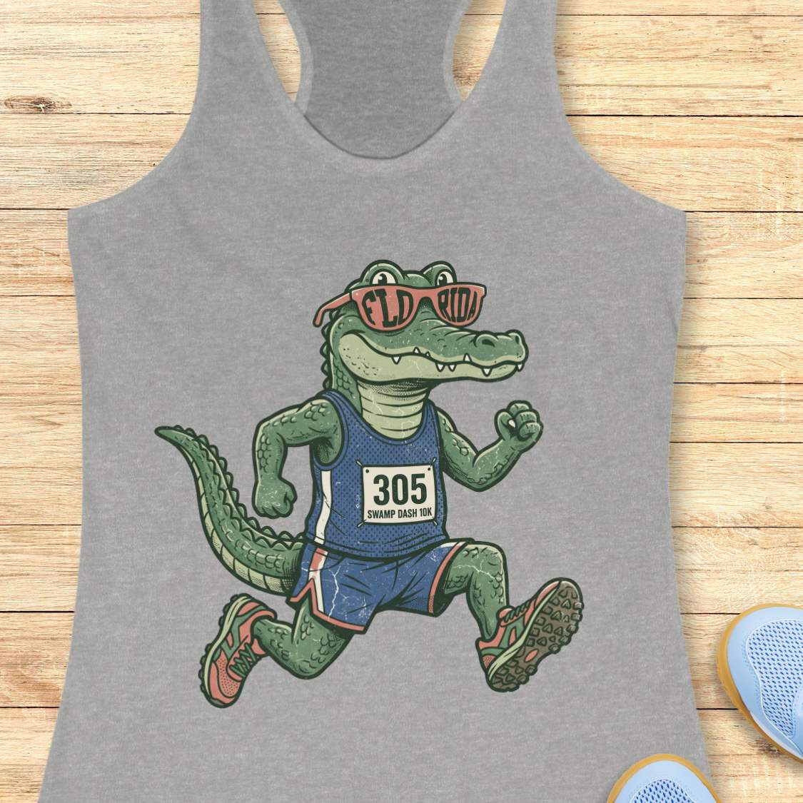 Funny Florida runner grey tank top featuring a cartoon alligator wearing running gear, race bib 305, and Florida sunglasses while running. Perfect apparel for Florida runners, women runners, marathon training, trail runners, swamp runners, and anyone who loves running in the heat and humidity.