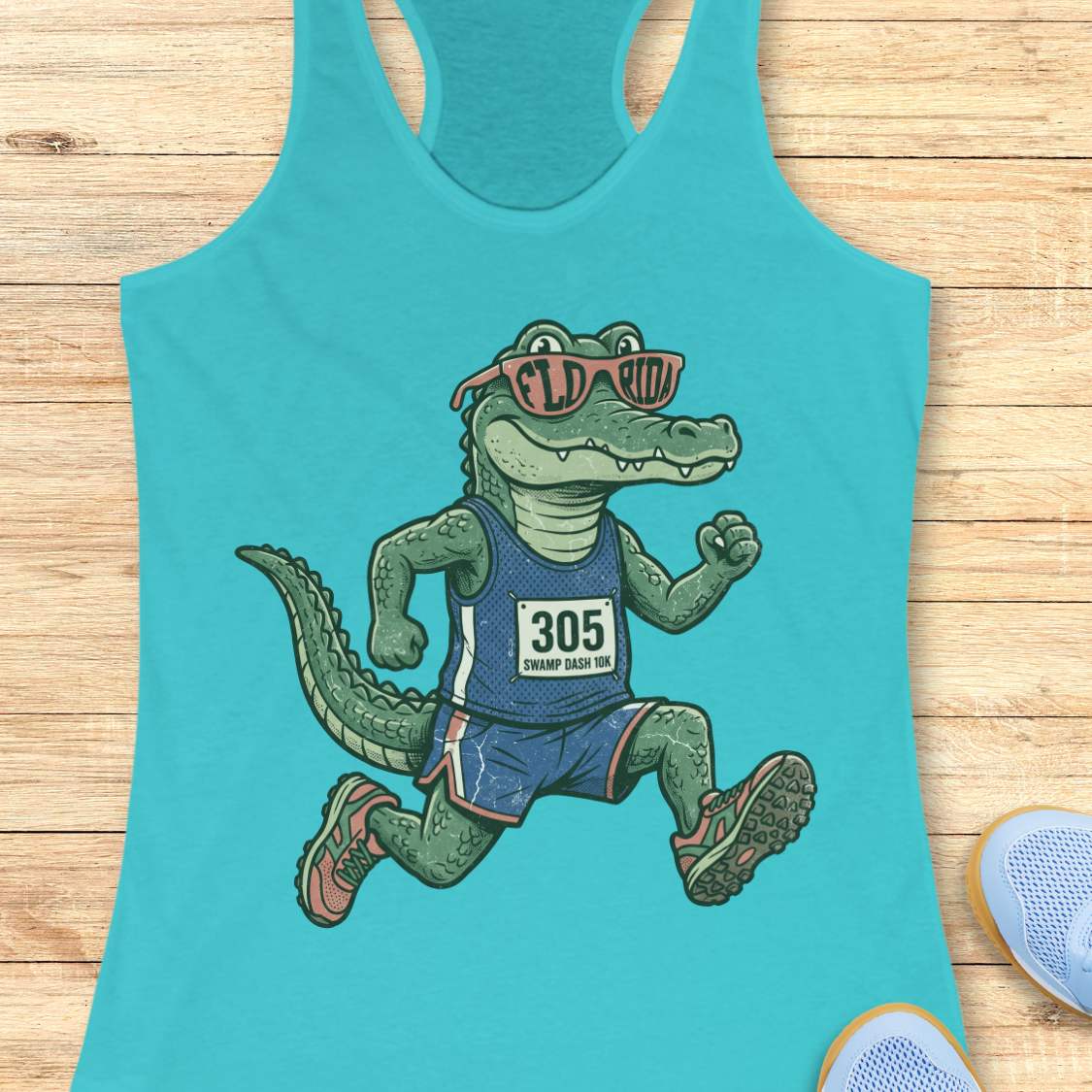 Funny Florida runner blue tank top featuring a cartoon alligator wearing running gear, race bib 305, and Florida sunglasses while running. Perfect apparel for Florida runners, women runners, marathon training, trail runners, swamp runners, and anyone who loves running in the heat and humidity.