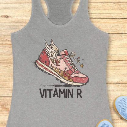 Funny women’s running grey tank top featuring a vintage winged running shoe with flames and the slogan “Vitamin R.” A playful design for runners, marathon runners, half marathon runners, trail runners, and women who consider running their favorite form of therapy and energy.