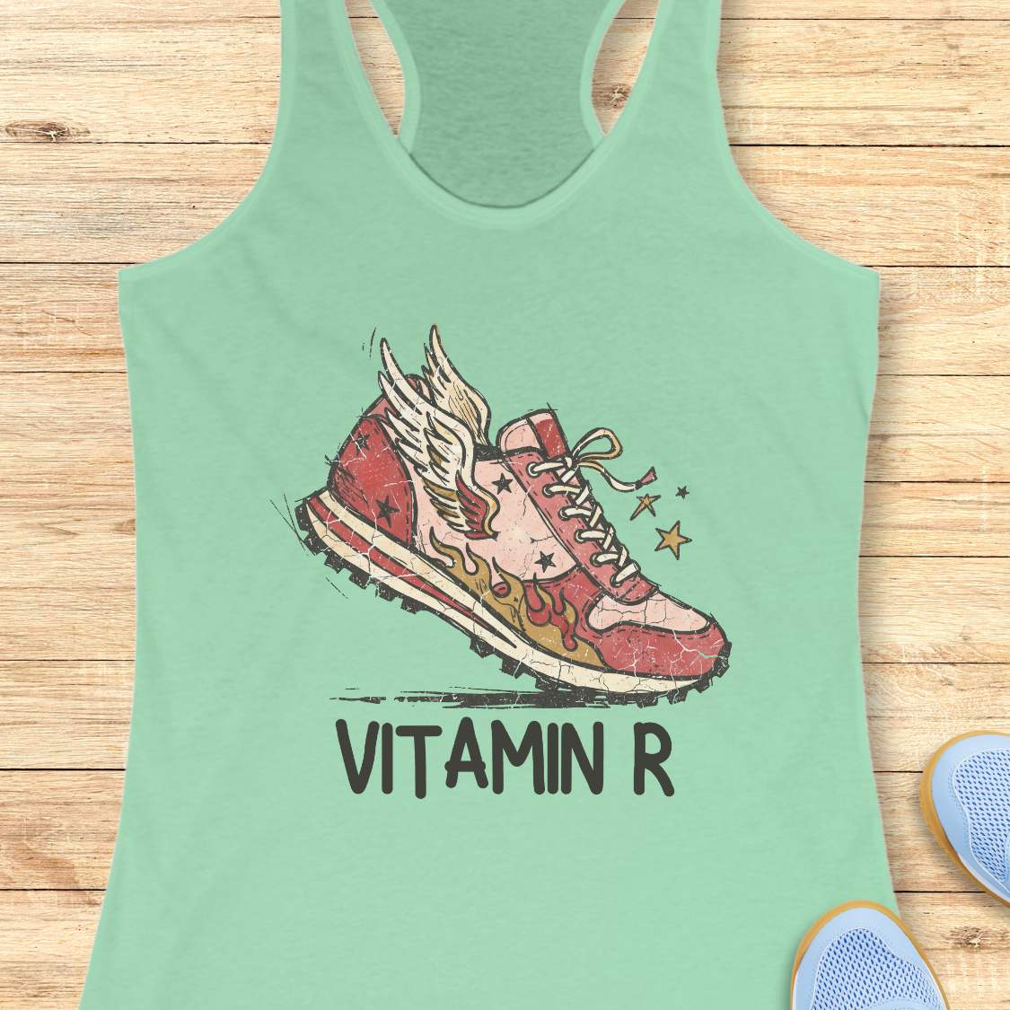 Funny women’s running mint tank top featuring a vintage winged running shoe with flames and the slogan “Vitamin R.” A playful design for runners, marathon runners, half marathon runners, trail runners, and women who consider running their favorite form of therapy and energy.