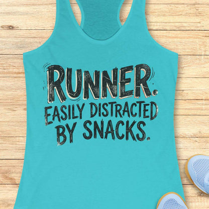 Funny runner tank top featuring the bold phrase “RUNNER. EASILY DISTRACTED BY SNACKS.” in distressed white typography on a blue racerback tank. Humorous running apparel for women who love running, carbs, post-run treats, energy gels, race snacks, and recovery food. Perfect for runners who are motivated by snacks, distracted by aid stations, and always thinking about their next treat after a run. Fun running gift for women runners, marathon runners, half marathon runners, 5K runners, trail runners, running 