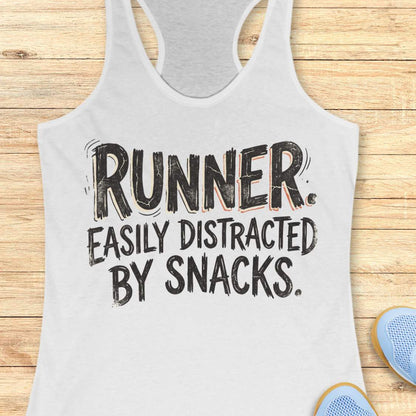 Funny runner tank top featuring the bold phrase “RUNNER. EASILY DISTRACTED BY SNACKS.” in distressed white typography on a white racerback tank. Humorous running apparel for women who love running, carbs, post-run treats, energy gels, race snacks, and recovery food. Perfect for runners who are motivated by snacks, distracted by aid stations, and always thinking about their next treat after a run. Fun running gift for women runners, marathon runners, half marathon runners, 5K runners, trail runners, running 