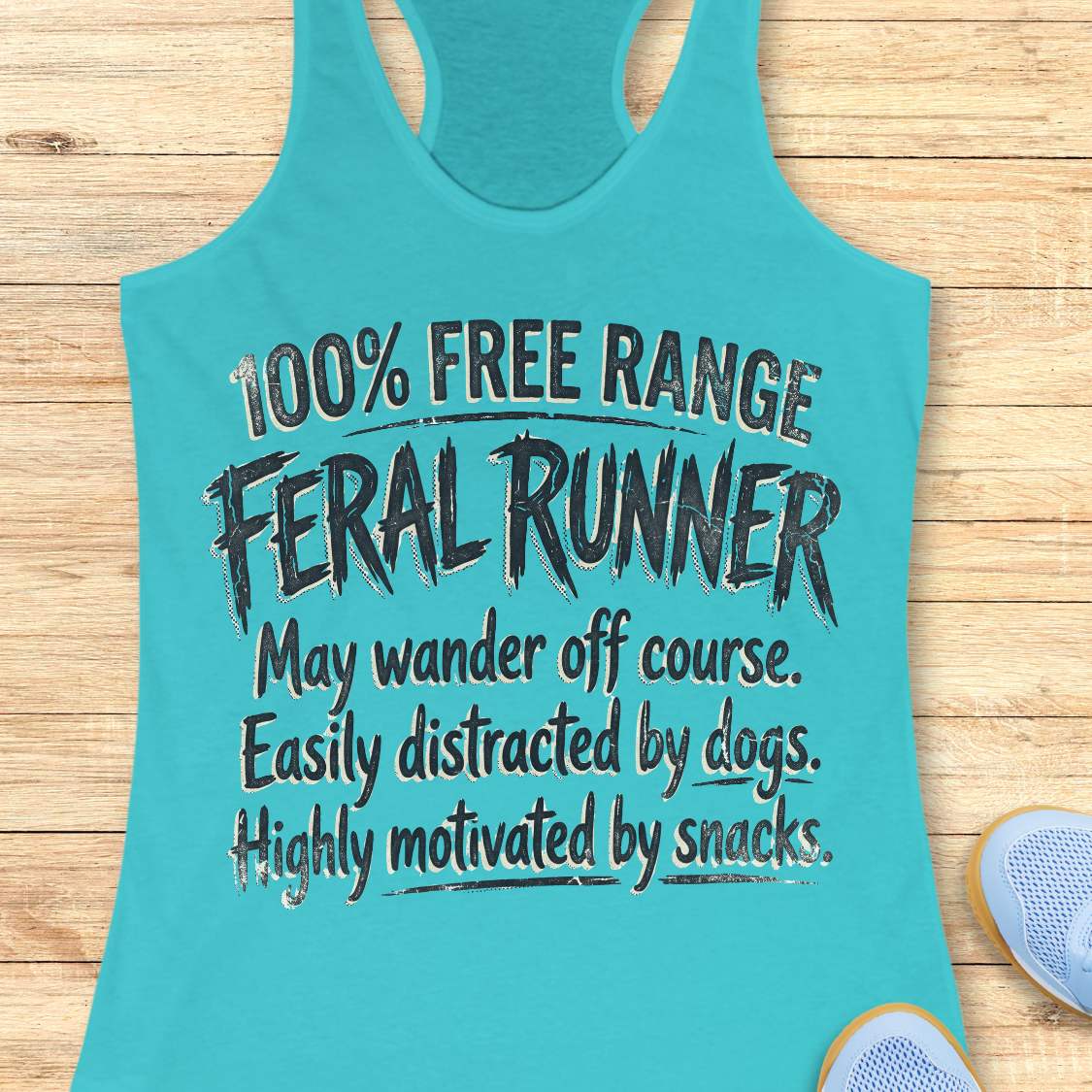 Funny women's running blue tank top featuring the phrase "100% FREE RANGE FERAL RUNNER" in bold distressed typography, followed by the humorous traits "May wander off course. Easily distracted by dogs. Highly motivated by snacks." This playful running design celebrates runners who embrace adventure, love dogs, enjoy trail running, and are always thinking about their next snack. Perfect for women runners, dog-loving runners, trail runners, marathon runners, half marathon runners, 5K participants,