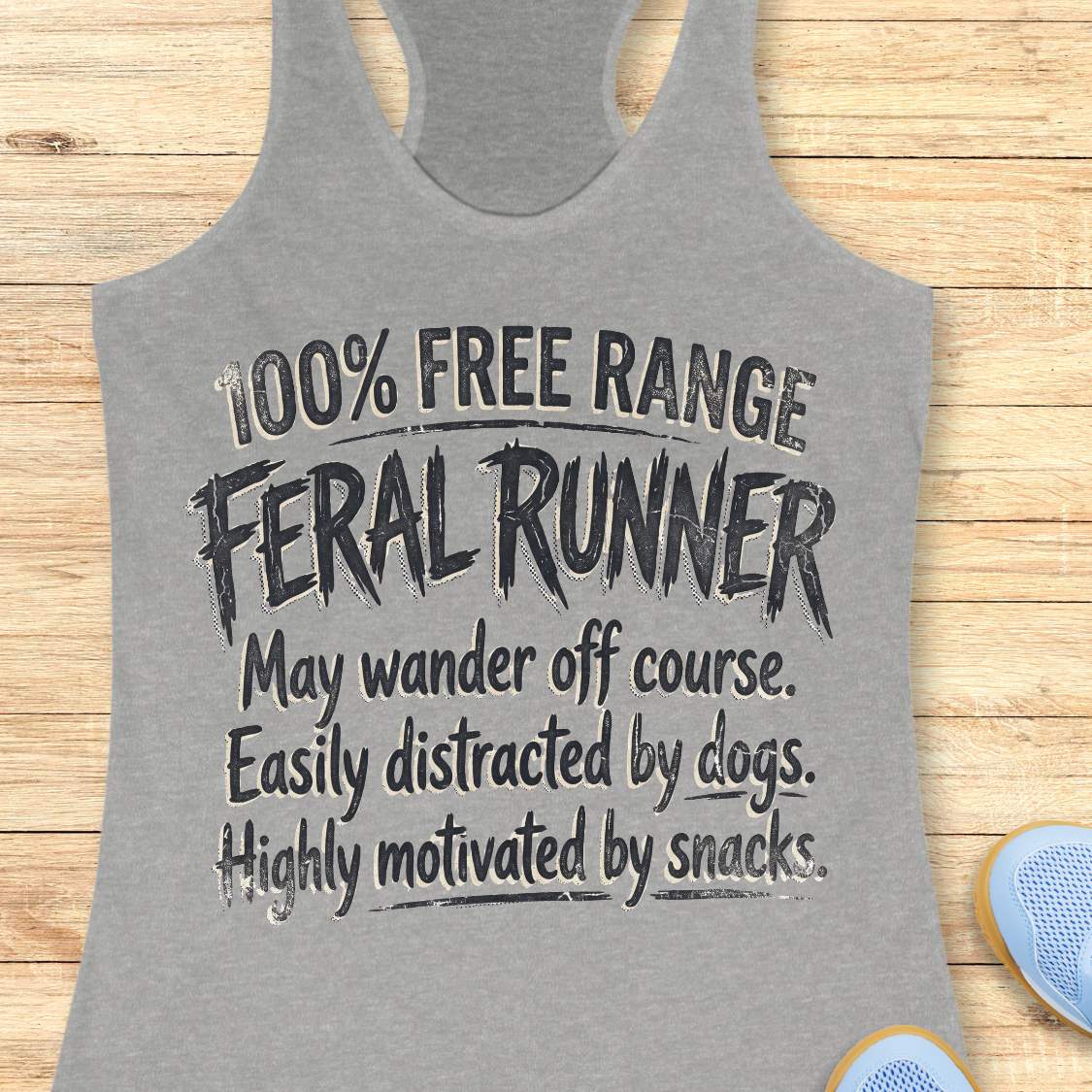 Funny women's running grey tank top featuring the phrase "100% FREE RANGE FERAL RUNNER" in bold distressed typography, followed by the humorous traits "May wander off course. Easily distracted by dogs. Highly motivated by snacks." This playful running design celebrates runners who embrace adventure, love dogs, enjoy trail running, and are always thinking about their next snack. Perfect for women runners, dog-loving runners, trail runners, marathon runners, half marathon runners, 5K participants,