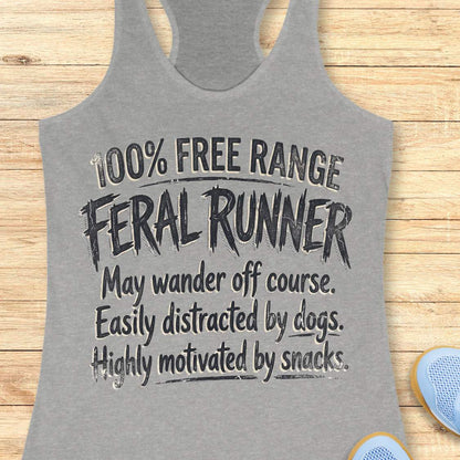 Funny women's running grey tank top featuring the phrase "100% FREE RANGE FERAL RUNNER" in bold distressed typography, followed by the humorous traits "May wander off course. Easily distracted by dogs. Highly motivated by snacks." This playful running design celebrates runners who embrace adventure, love dogs, enjoy trail running, and are always thinking about their next snack. Perfect for women runners, dog-loving runners, trail runners, marathon runners, half marathon runners, 5K participants,