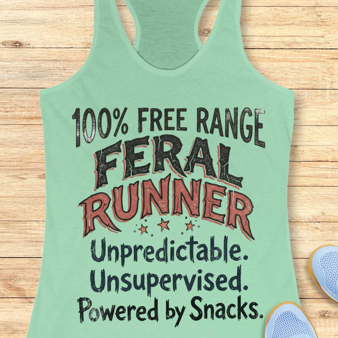 Funny women's running tank top featuring the bold phrase "100% FREE RANGE FERAL RUNNER" with the humorous personality traits "Unpredictable. Unsupervised. Powered by Snacks." displayed in distressed vintage-style typography on a mint racerback tank. This playful running design celebrates free-spirited runners who embrace adventure, independence, and a love of post-run treats. Perfect for women runners, trail runners, marathon runners, half marathon participants, 5K runners, running club members, and 