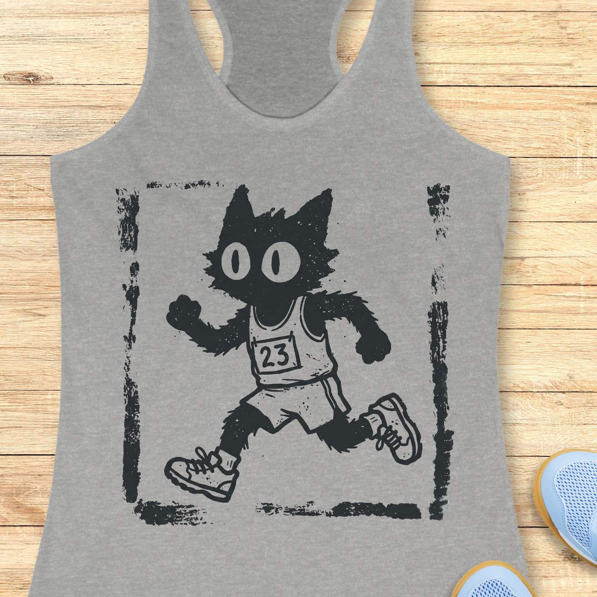 Women's grey racerback tank top with a retro distressed running cat graphic. The design showcases a quirky black cartoon cat with oversized eyes sprinting in running gear, including a race bib marked 23, shorts, and sneakers. Rendered in a vintage hand-drawn illustration style with grunge screen-print textures and a weathered border, the artwork blends running culture with cat lover humor. Ideal apparel for women who enjoy running, marathon training, race day events, jogging, trail running, fitness, and fun