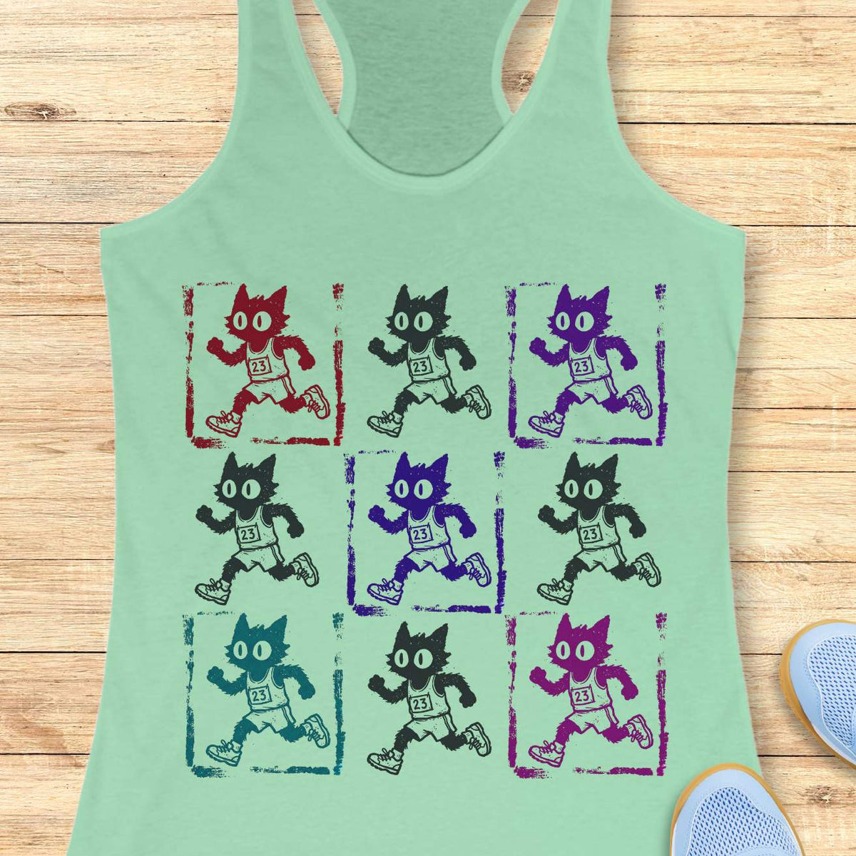 mint women's racerback tank top with a retro pop-art running cat design. The graphic features a 3x3 grid of scruffy cartoon cats sprinting in race gear, each wearing a race bib marked 23. Rendered in a distressed screen-print style with vintage textures and colorful variations in red, purple, teal, magenta, and black, the artwork combines running culture, cat lover humor, and indie cartoon aesthetics. This unique running tank is ideal for women runners, marathoners, joggers, trail runners, 