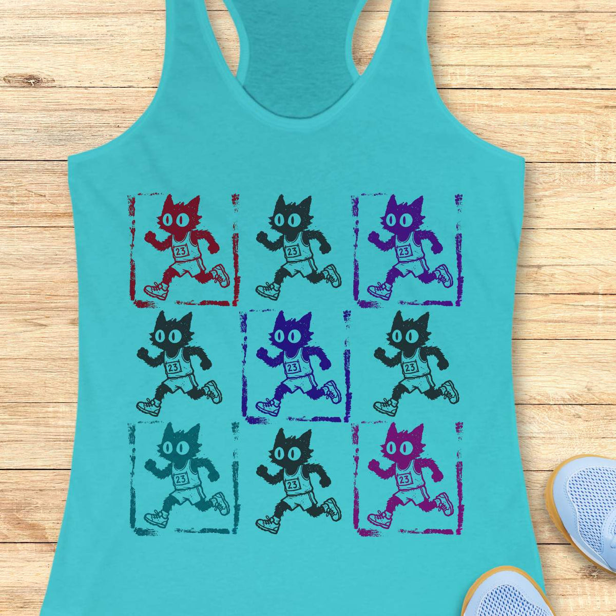 blue women's racerback tank top with a retro pop-art running cat design. The graphic features a 3x3 grid of scruffy cartoon cats sprinting in race gear, each wearing a race bib marked 23. Rendered in a distressed screen-print style with vintage textures and colorful variations in red, purple, teal, magenta, and black, the artwork combines running culture, cat lover humor, and indie cartoon aesthetics. This unique running tank is ideal for women runners, marathoners, joggers, trail runners, 
